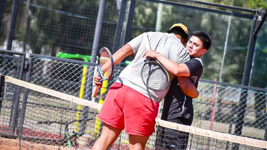 Dos jugadores de Academia Vivo Tenis se abrazan en la red al terminar un partido